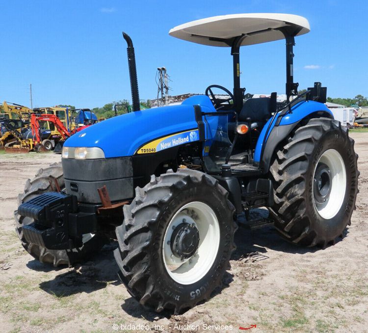 A blue New Holland tractor with big black wheels