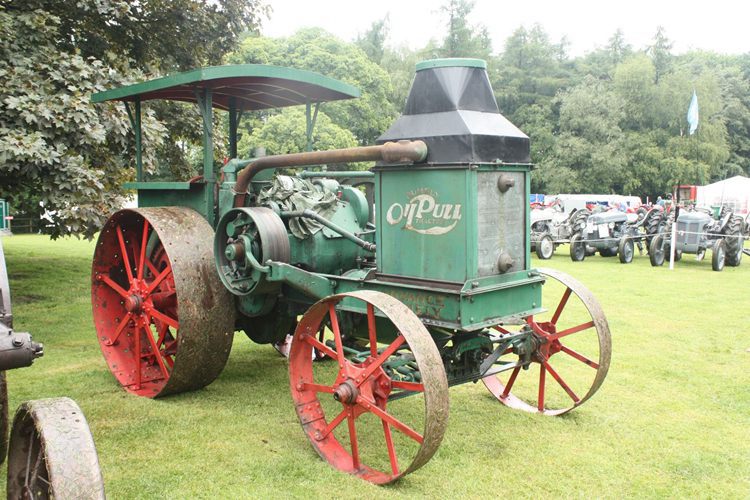 A green Advance-rumely tractor with red wheels